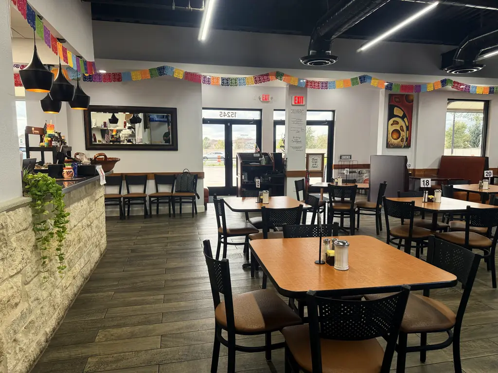 El comedor bajo papel picado y lámparas negras colgantes